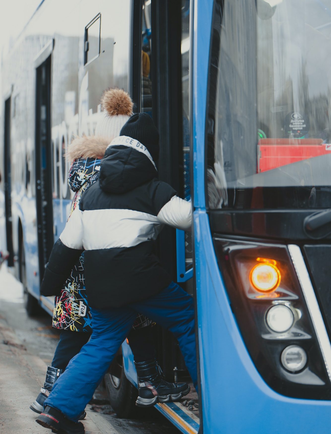 the-girls-enter-the-doors-of-a-blue-bus-that-has-arrived-at-the-bus-stop-.jpg the-girls-enter-the-doors-of-a-blue-bus-that-has-arrived-at-the-bus-stop-.jpg